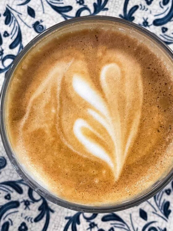 cup of coffee with heart of foam in blue pattern plate