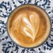 cup of coffee with heart of foam in blue pattern plate